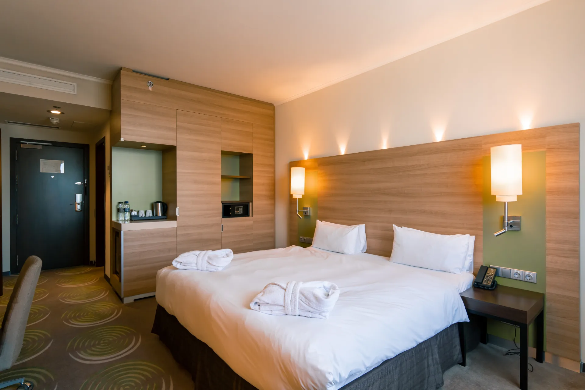 Hotel room made up with fresh towels and crisp white linen